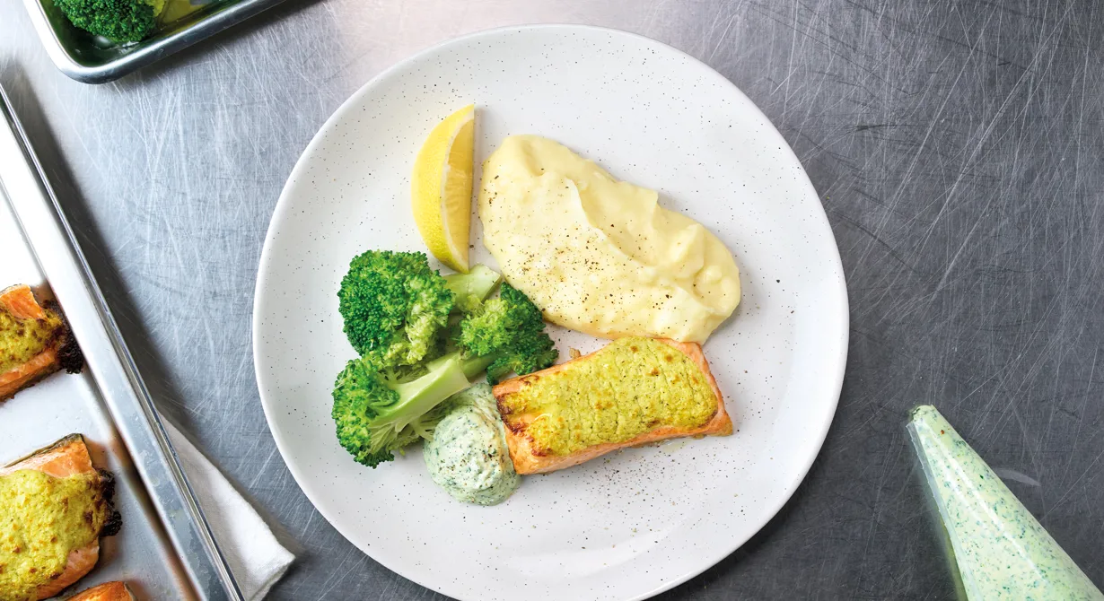 En lyxig skollunch där laxen får ett täcke av krämig vitost mixad med broccoli. Servera med potatismos, kokt broccoli och en örtsås med krämig vitost.